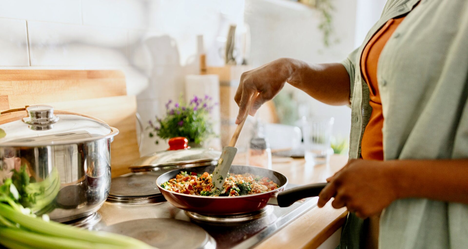 A woman cooks quinoa vegetable dish