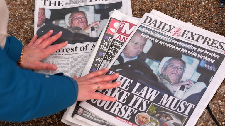 A journalist looks at today's newspaper front pages in London, Friday, Feb. 20, 2026