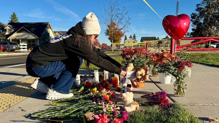 A person places flowers at a makeshift memorial on the other side of Silver Rail Elementary School in Bend, Oregon, on Friday, October 16, 2026, a day after a deadly shooting.