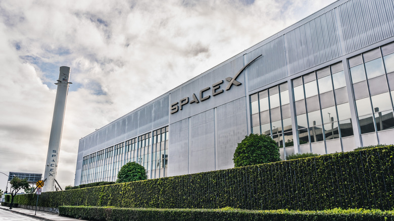 SpaceX manufacturing facility with the company logo prominent on the building.