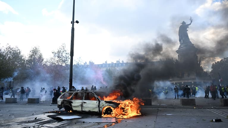 A car burns at Place de La Republique during a protest against rising living costs in Paris