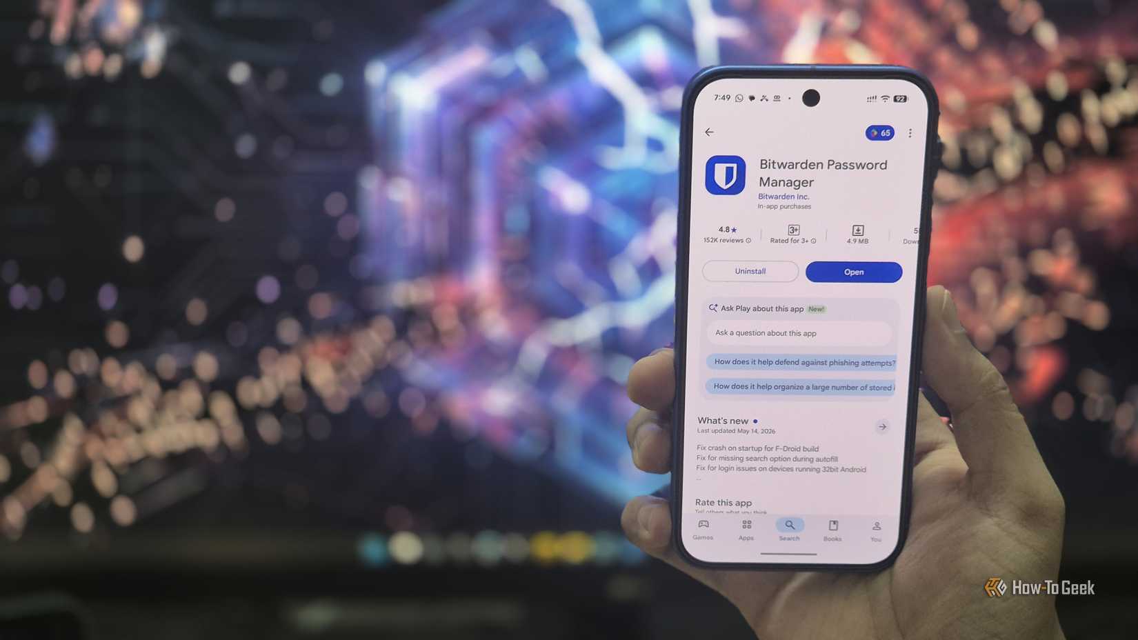 Bitwarden app open in Google Play Store in front of a monitor with a broken shield.