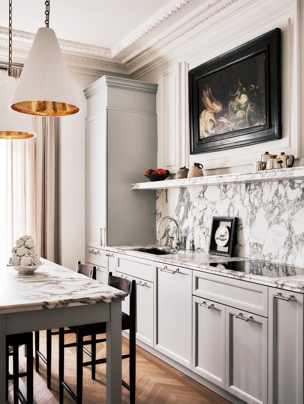 Modern kitchen with marble countertops, pendant lighting, and a stylish blend of cabinetry and decor.