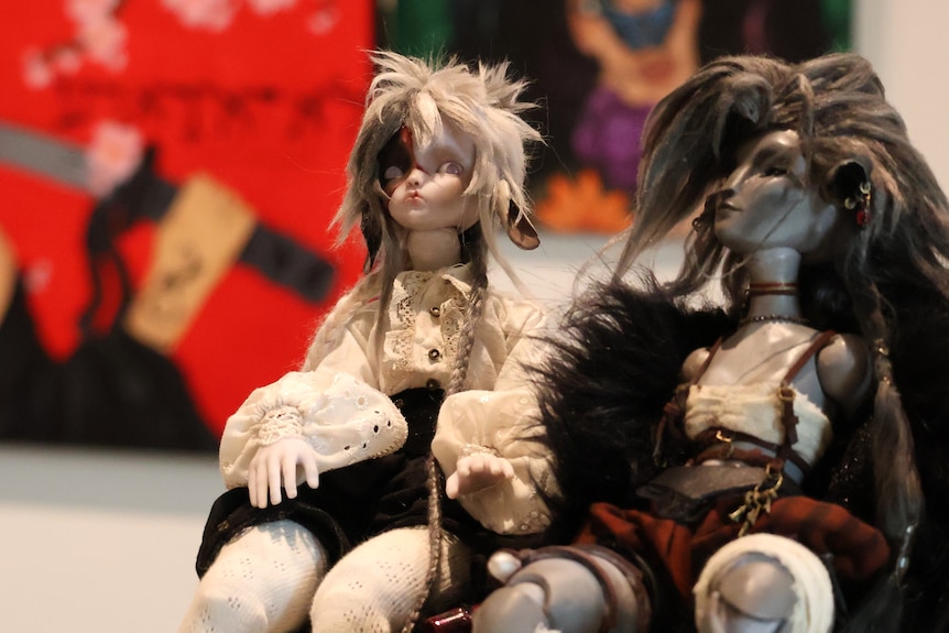 Two dolls with a gothic style at a gallery.