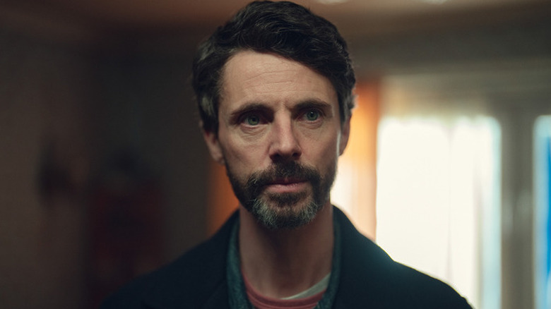 Carl Morck (Matthew Goode) standing inside a house on 