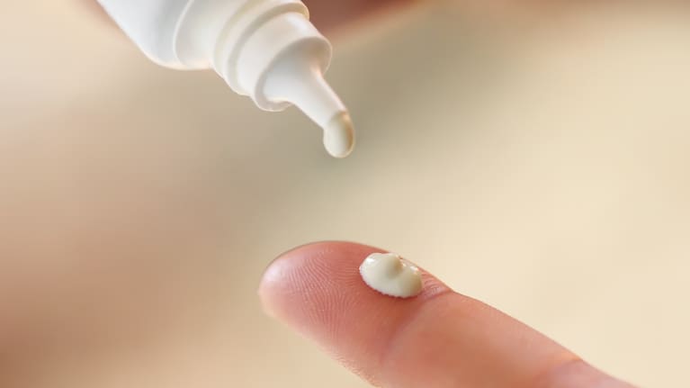 Drop of cream from a tube stock photo