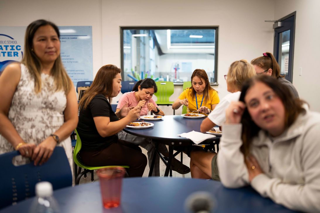 Three teachers newly arrived from the Philippines eat inside the school as they meet with the Hettinger community and their colleagues.