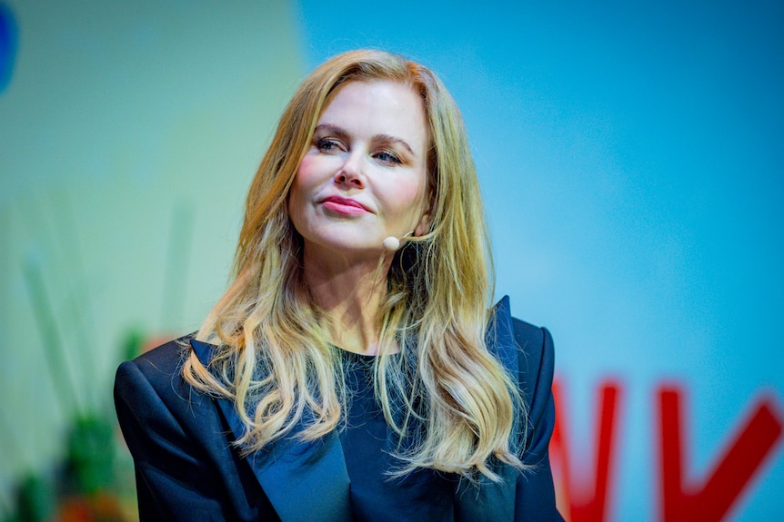Nicole Kidman with a lapel mic on looking away from the camera with a considered look on her face
