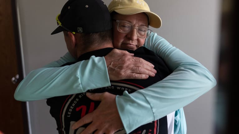 UAW Local 402 members, Brad Cloud, left, and Marianne Donnelly, right, embrace at the union hall, in Springfield, Ohio