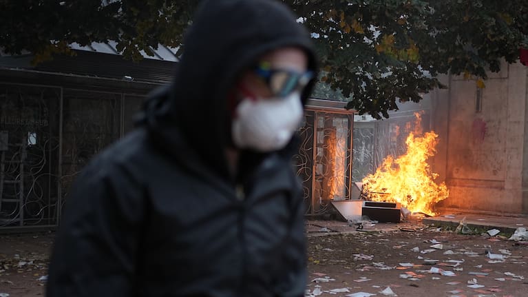 Protesters walks past a burning bin during a demonstration against rising living costs, joining students' grievances, in Lyon