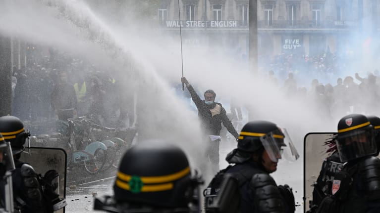 Protesters face police during a demonstration against rising living costs, joining students' grievances, in Paris