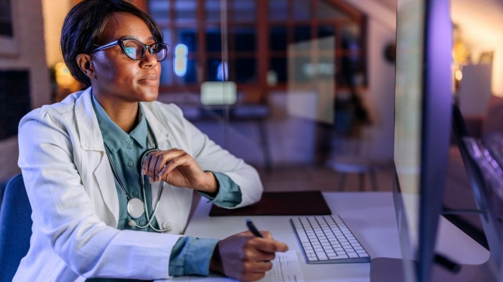 A doctor looking at a computer screen.