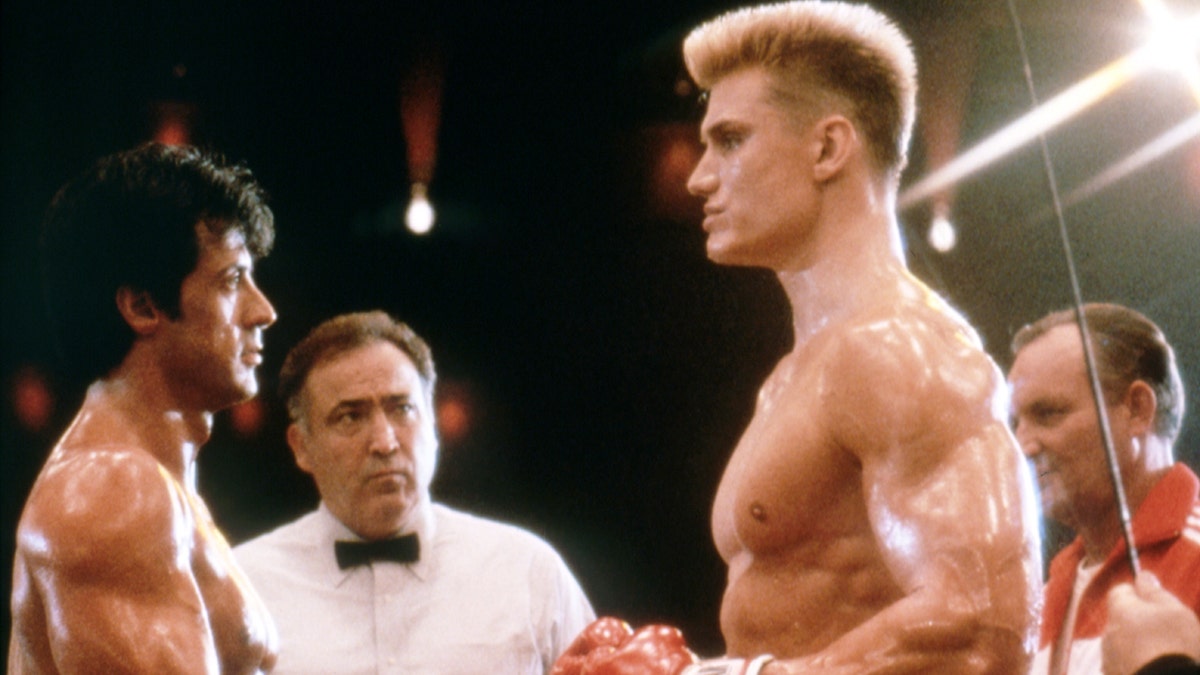 Dolph Lundgren as Ivan Drago facing opposite Sly Stallone in a boxing ring.