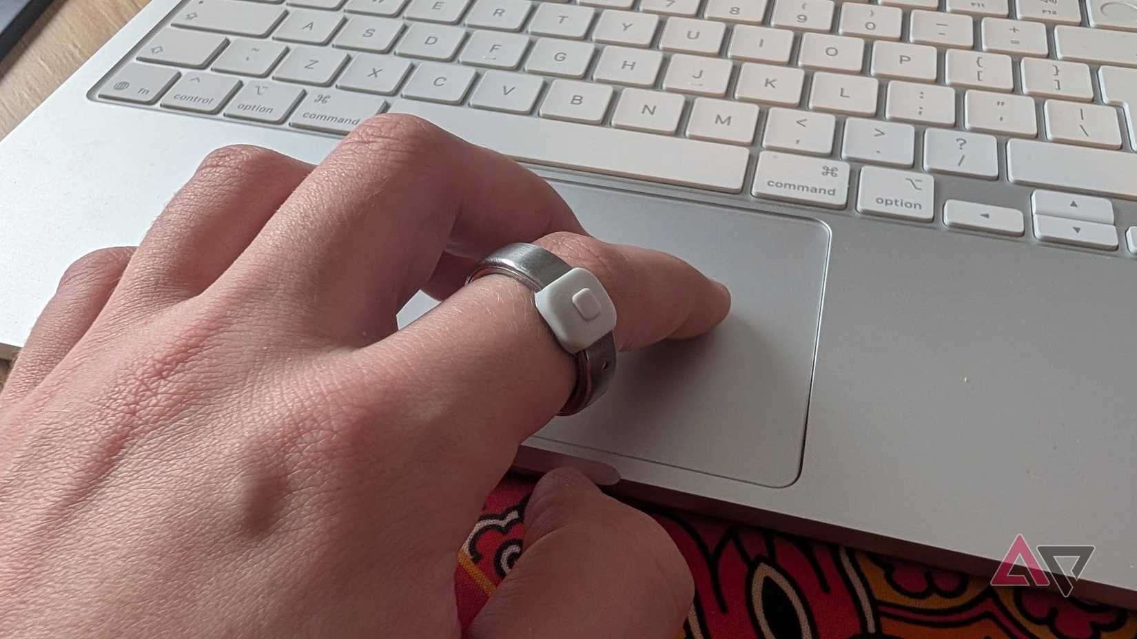 hand using trackpad wearing silver and white ring