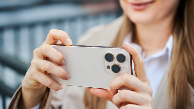 A person capturing content on an iPhone 16 Pro.