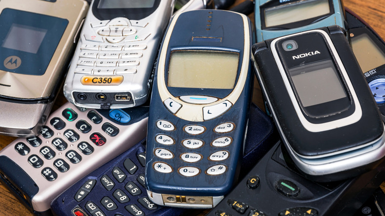 Assorted old cell phones, including classic Nokia and Motorola models, piled together.