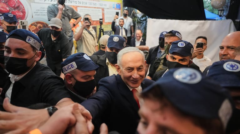 Israeli Prime Minister Benjamin Netanyahu, leader of the Likud party, gestures to supporters as security personnel surround him.