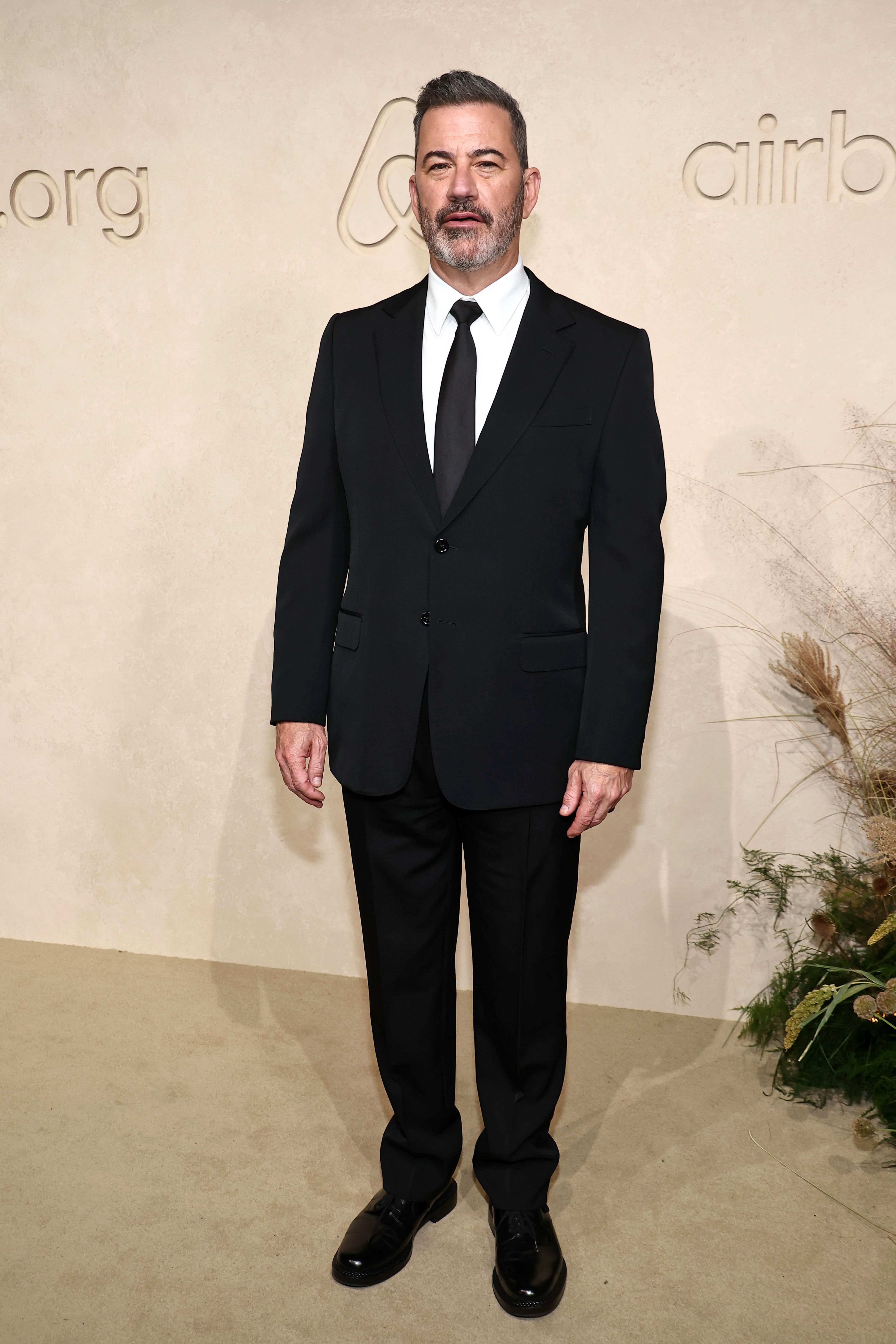 Jimmy Kimmel wearing a black suit and tie at the Airbnb.org Gala in Los Angeles, California.