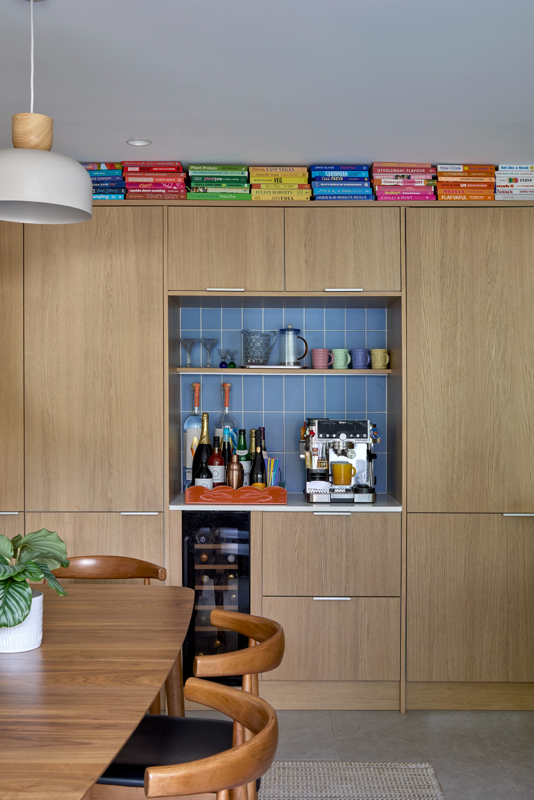wooden cabinetry in a kitchen with a coffee bar setup and a wine fridge