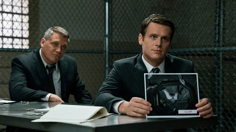 Holt McCallany as Bill Tench and Jonathan Groff as Holden Ford, showing a picture in Mindhunter.