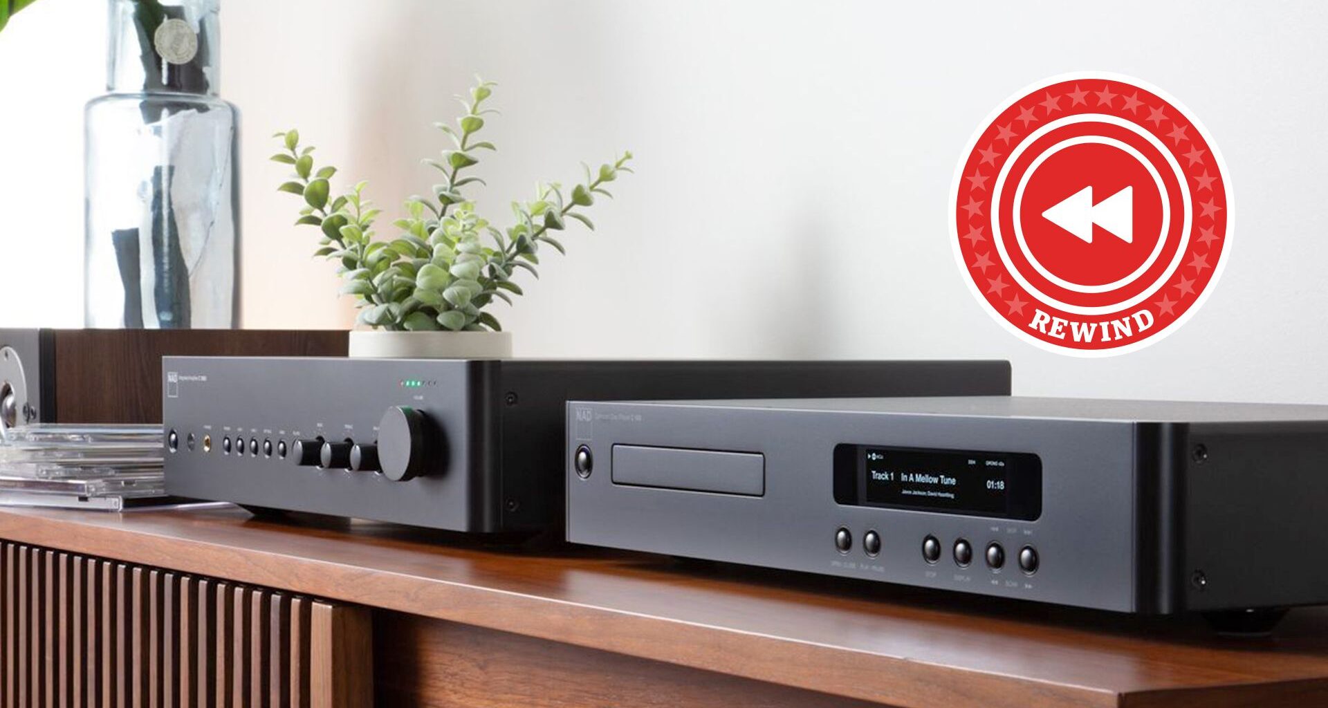 NAD C 359S streaming amp and C 56 CD player sitting next to each other on a sideboard with a red Rewind roundel in the top right corner of the image