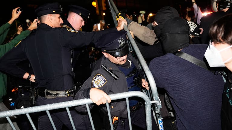 New York City police try to block protestors near the scene of a shooting.