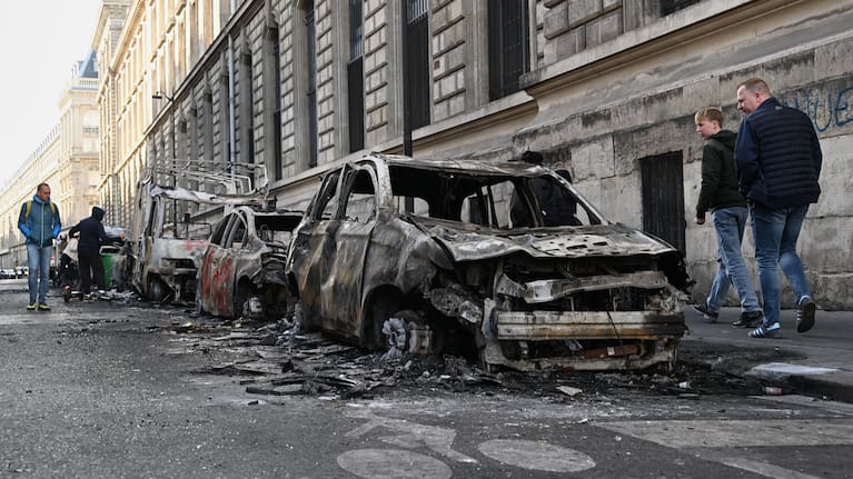 People look at charred cars the day after a demonstration against rising living costs, joining students' grievances, in Paris, Sunday, Oct. 18, 2026.
