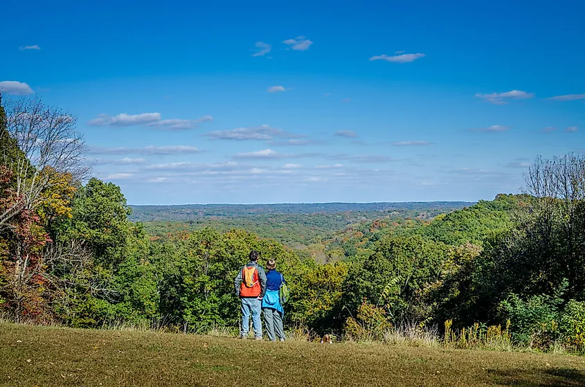 Hikers at an overlook above wooded ridges in Brown County State Park, Indiana.