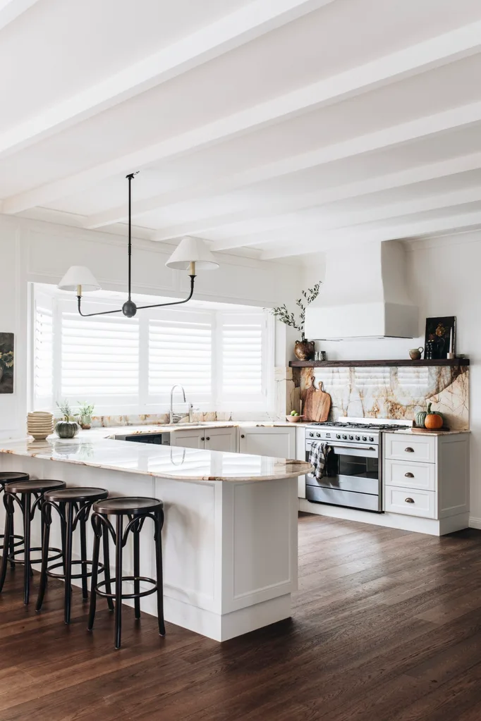 A modern country kitchen with stone benchtops, timber barstools and autumnal decor