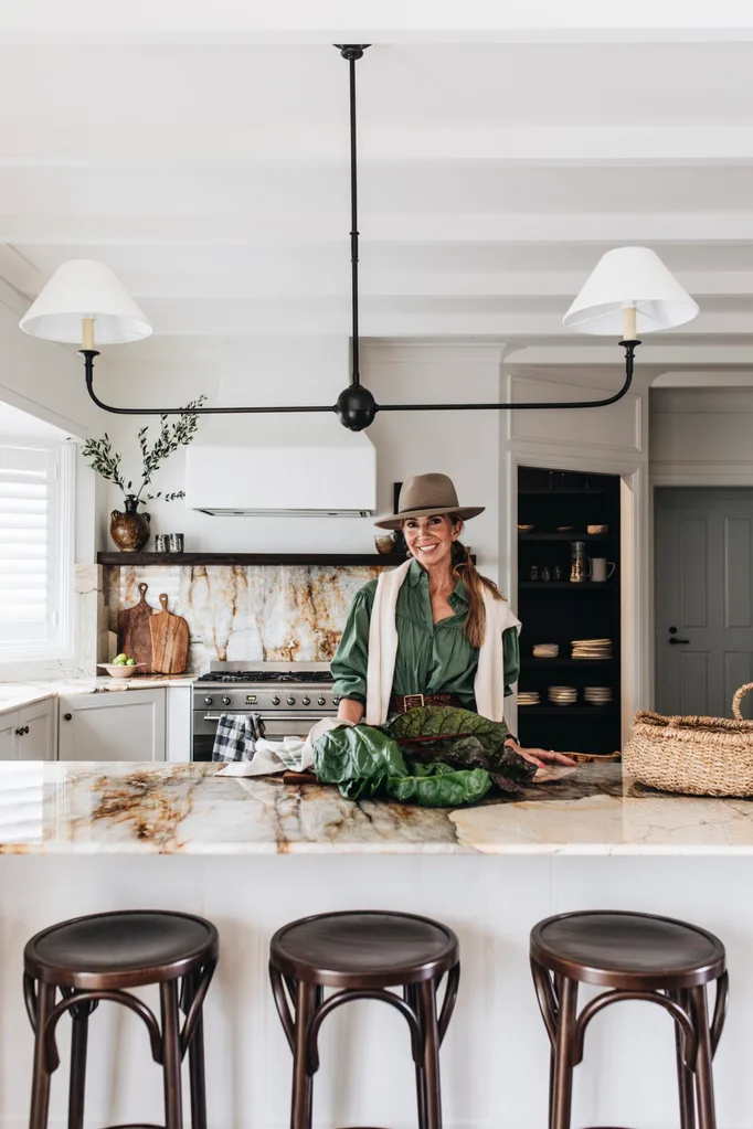 Interior designer Emma Lane in her modern country kitchen with fresh greens on the benchtop