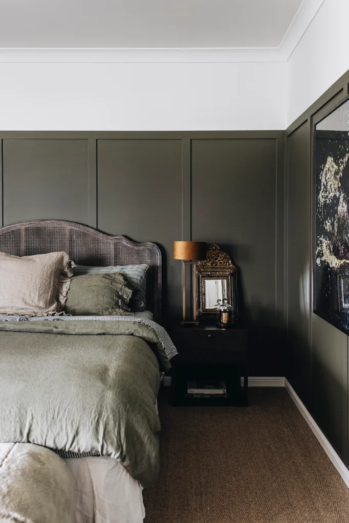 A grey-green coloured bedroom with linen bedding and an antique desk