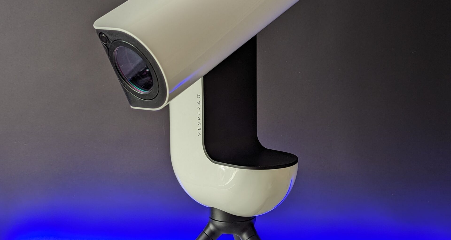 Vaonis Vespera II's optical tube assembly slewed down in front of a black background with a blue light shining