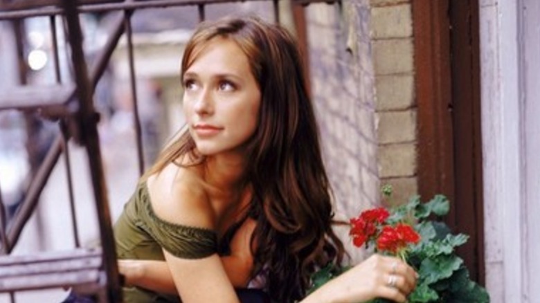 Jennifer Love Hewitt as Sarah on Time of Your Life touching flowers on apartment balcony