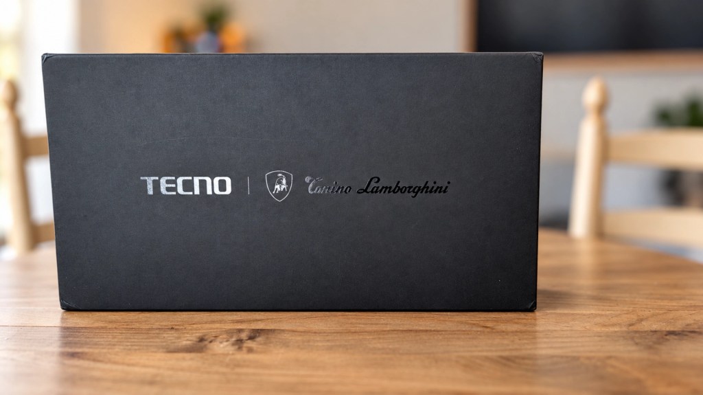 Black packaging box featuring TECNO and Automobili Lamborghini logos on a wooden table.