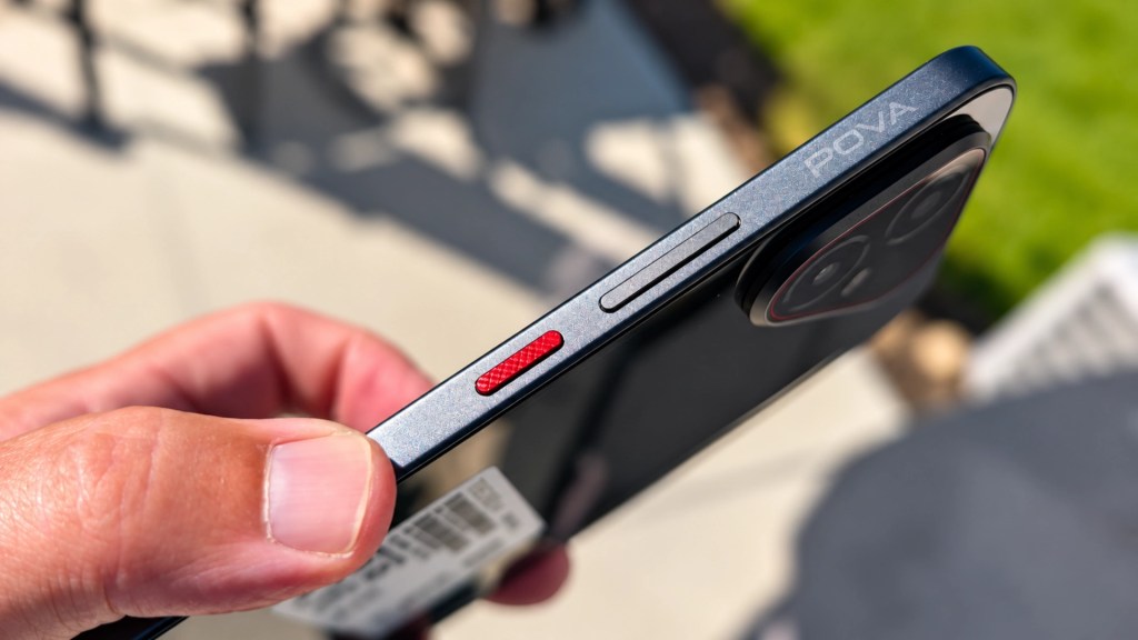 A close-up view of a person's hand holding a smartphone, featuring a red button and the brand name 'POVA' visible on the side.