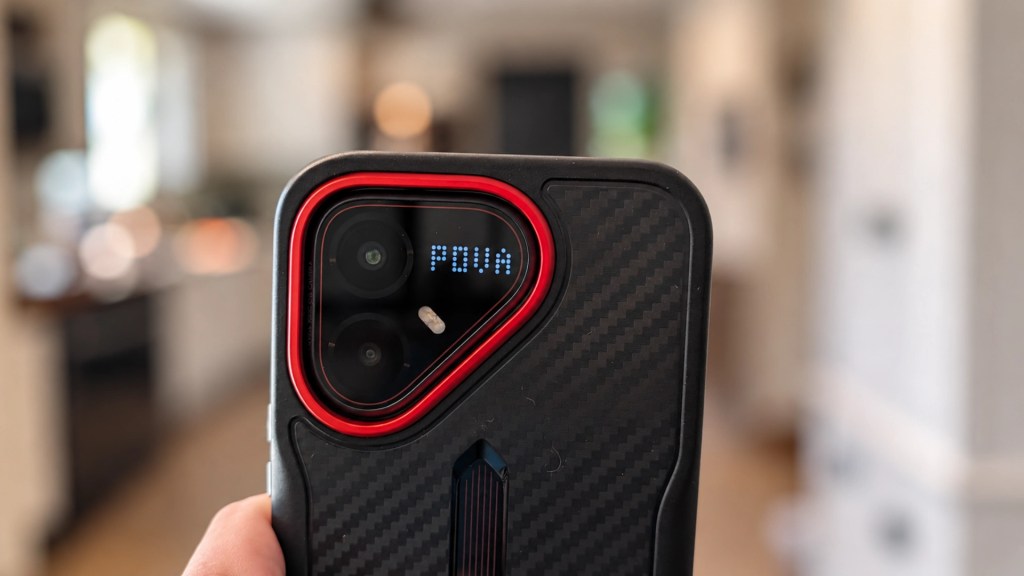 Close-up of a smartphone case with a carbon fiber texture, featuring a red accent around the camera area and an illuminated display showing the word 'POWER'.