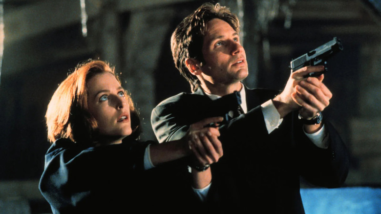 Gillian Anderson and David Duchovny as Agents Scully and Mulder draw their weapons on The X-Files
