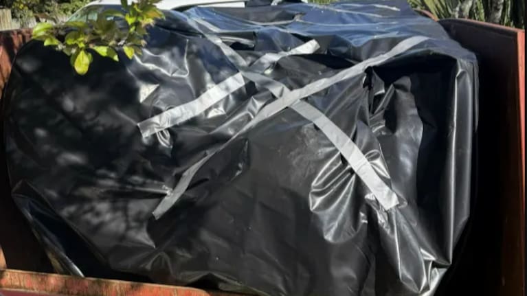 To throw away contaminated waste, cleaners line skip bins and cover them. They try to get them off-site before nightfall when bin scavengers might come.