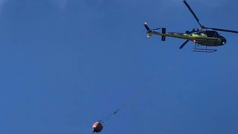 A helicopter reported to the scene, carrying a monsoon bucket of water.
