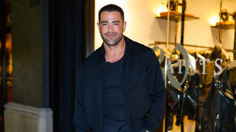Jesse Metcalfe standing in front of a clothing store