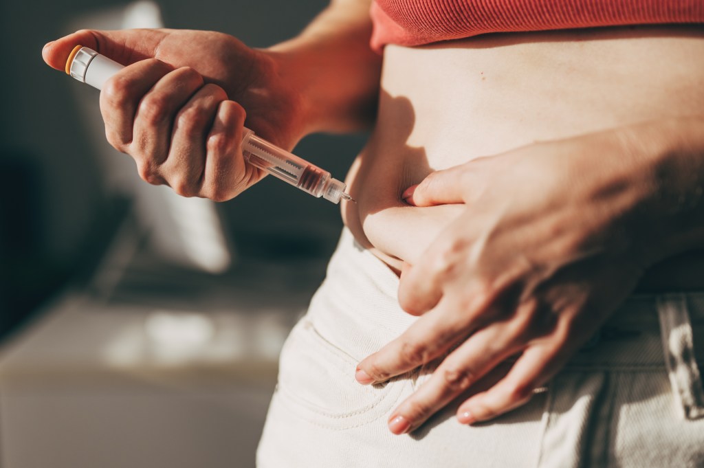 A woman injecting GLP-1 at home.