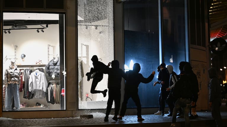 Youths break a store window during clashes between protestors and police in Paris, Sunday, Oct. 18, 2026.