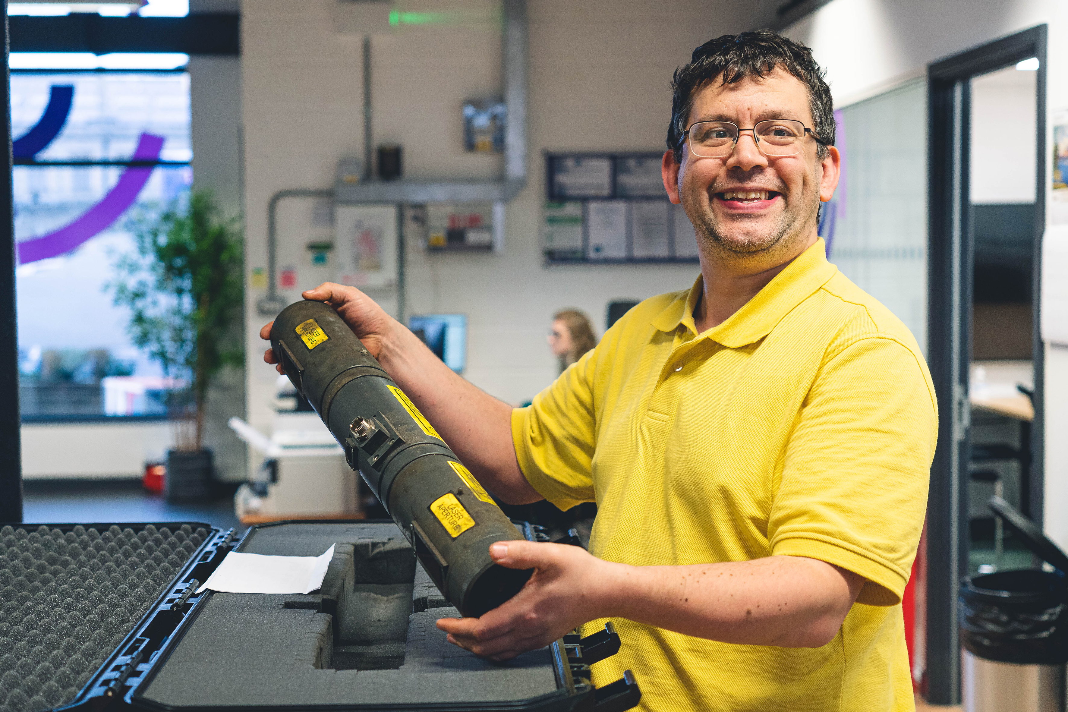 A man holding a laser tube from a track geometry measurement system.