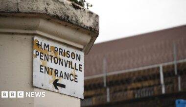 A sign on a column saying H.M. Prison Pentonville, and underneath the words Entrance and an arrow pointing to the left.