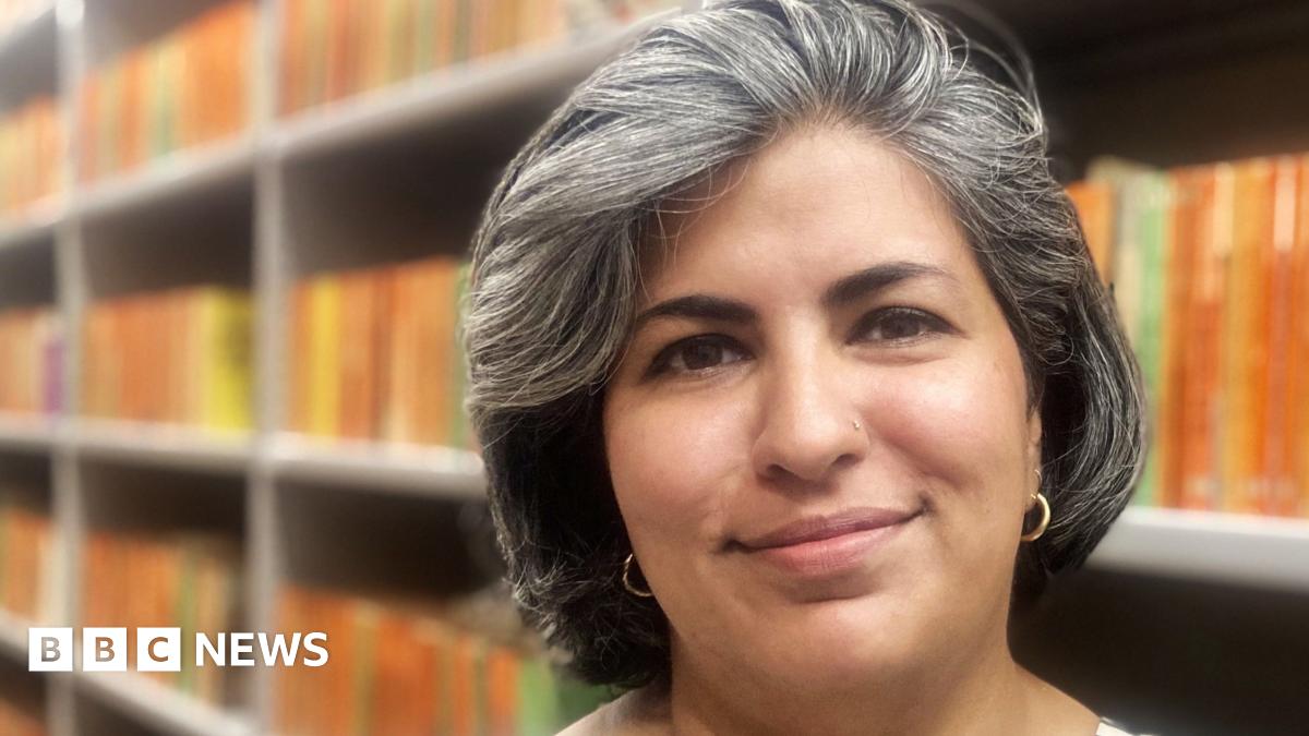 The spines of several orange Penguin paperback books are on a shelf. Only the one nearest the camera is in focus. The Penguin logo can be seen on each.