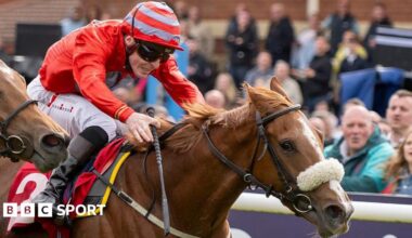 Jockey Rowan Scott dressed in red silks riding Boyne Lady to victory