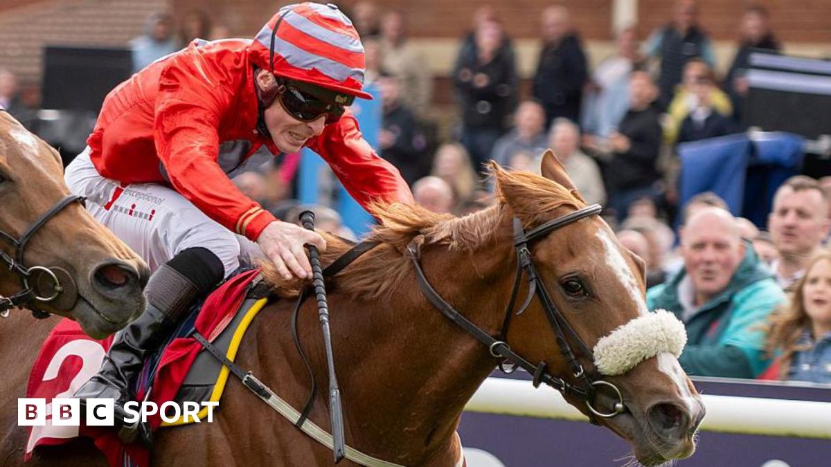 Jockey Rowan Scott dressed in red silks riding Boyne Lady to victory