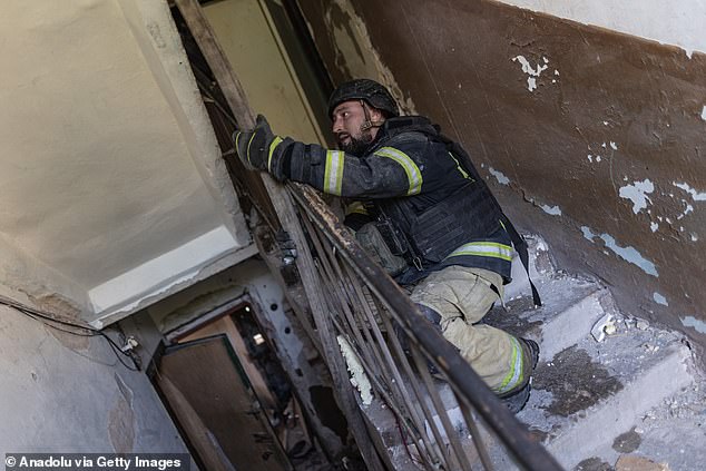 Ukrainian emergency service workers extinguish a fire in a residential building following a strike