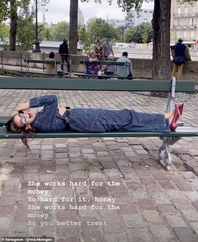 Michelle Keegan, 38, cut a stylish figure in a navy jumpsuit as she joked she 'works hard for the money' while relaxing on a bench in Paris during lavish trip in an Instagram video on Friday