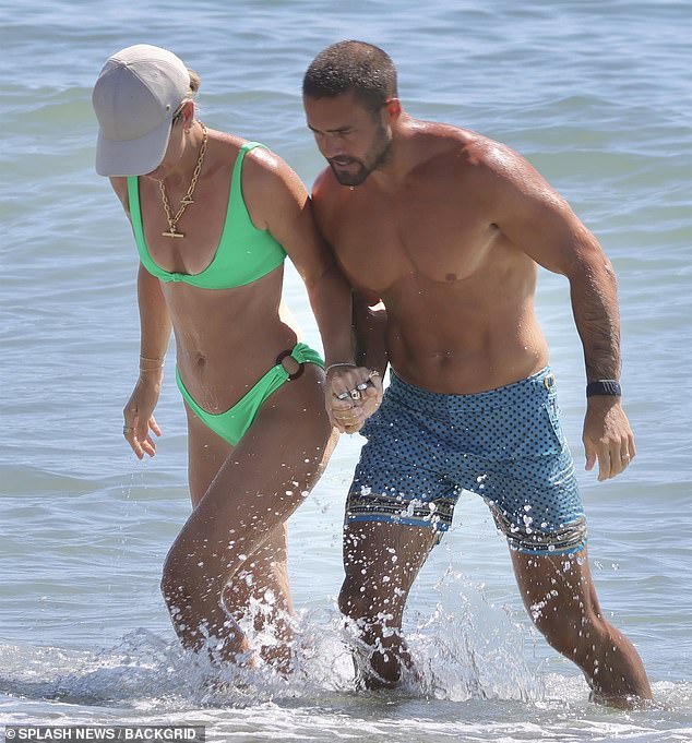 Meanwhile, Spencer showcased his washboard abs as he splashed in the sea wearing a pair of blue shorts